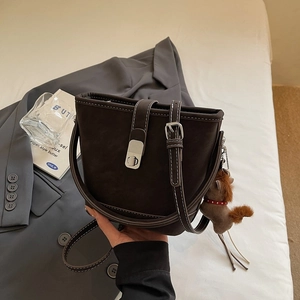 Detail view of coffee brown bucket bag with white stitching and silver twist lock
