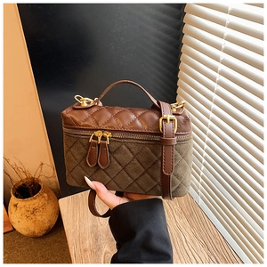 Detail of vintage quilted box bag in brown leather and suede with gold zippers