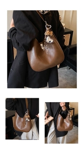 Detail of dark brown hobo bag with silver heart pendant and leopard bow accessory