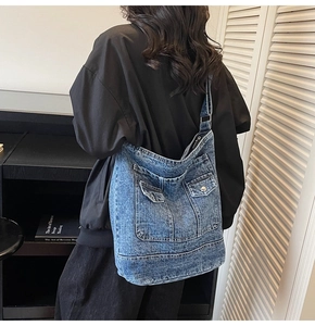 Vista dettagliata della borsa tote in denim lavato con tasche con patta e fibbia in metallo