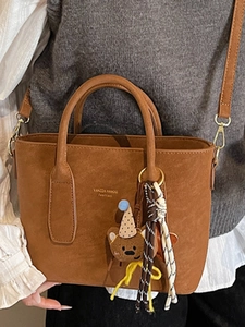 Sac à main marron en cuir dépoli avec breloque d'ours et bandoulière réglable pratique