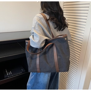 Gros plan du grand sac cabas en toile montrant les boucles en métal et détails en cuir