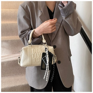 Close-up of cream bowling bag featuring 3D embossed letters and stylish woven accessories