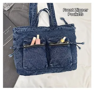 Detail view of denim tote bag with two front zipper pockets storing small cosmetics