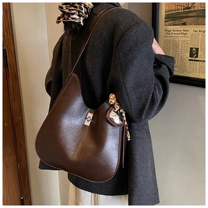 Detail of dark coffee Hobo bag with silver twist lock and leopard print scarf accessory