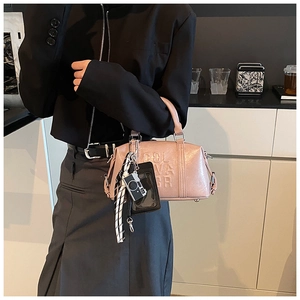 Pink gold patent leather bowling bag with SOL VA GR embossing and stylish charms