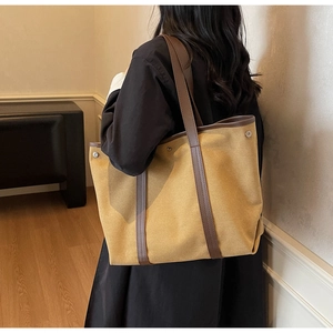 Détail d'un grand sac fourre-tout en toile avec boutons-pression latéraux et anses en cuir