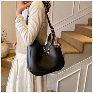 Detail of black Hobo bucket bag with silver buckle and leopard print heart charm decoration