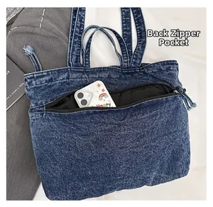 Detail of blue denim tote bag showing back zipper pocket for anti-theft storage