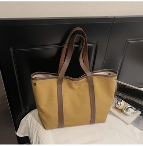 Détail du sac cabas en toile avec anses en cuir marron et boucles pour le quotidien