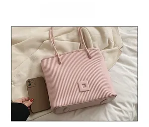 Detailed close-up of pink pleated tote bag with slim shoulder straps and size comparison