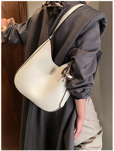Detail of a large cream hobo bag with a silver buckle and leopard print scarf on strap