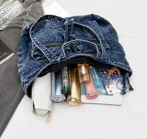 Detail of the large capacity dark blue washed denim tote bag showing interior storage space
