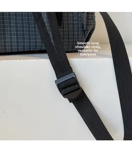 Detail of adjustable smooth black shoulder strap and durable ripstop grid fabric on the backpack