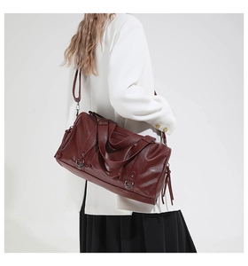 Seitenansicht einer großen Vintage-Motorradtasche in Burgund, getragen von einem Model