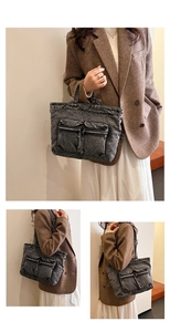 Detail view of washed denim tote bag with dual front zipper pockets and vintage texture