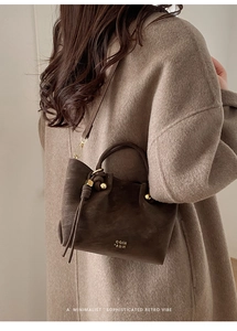 Détails du sac seau marron café vintage avec finitions dorées et plis ondulés chic
