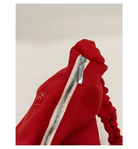Detailed close-up of the smooth silver zipper and red plush fabric on this tote bag