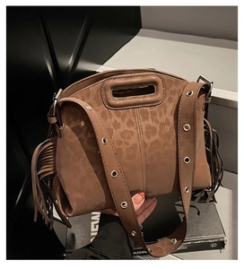 Détail du sac bandoulière en daim marron avec gaufrage léopard et franges sur les côtés