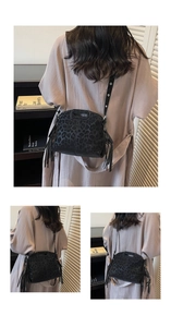 Détail du sac bandoulière noir à imprimé léopard avec longues franges et suédine