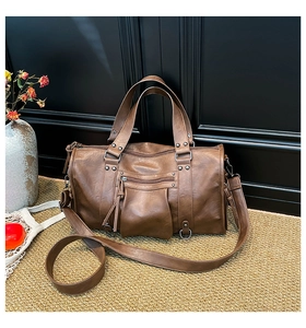 Detailansicht der großen braunen Vintage-Leder-Kissentasche mit Nieten und breitem Gurt