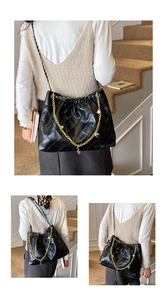 Detail of black quilted shoulder bag with golden chain and pearl star heart charms