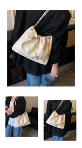 Close-up of cream quilted bucket bag with drawstring and decorative metal chains
