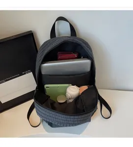 Detail view of the spacious inner compartment with laptop sleeve in a grey checkered backpack