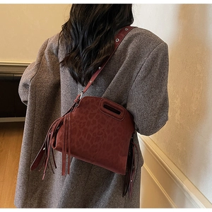 Détail du sac bandoulière bordeaux en daim à imprimé léopard avec de longues franges
