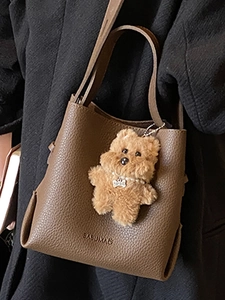Fashionable dark brown leather bucket bag with plush charm and Babuma logo branding