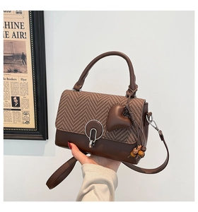 Close-up of retro shoulder bag with houndstooth tweed pattern and metal ring buckle