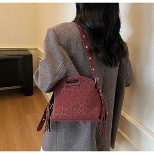 Détail du sac bandoulière léopard bordeaux avec franges et bandoulière à œillets