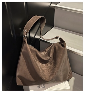 Vue détaillée du motif marguerite embossé sur une surface de sac cabas en daim brun