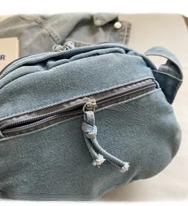 Dettaglio della borsa shell in denim con cerniera scorrevole e cordoncino intrecciato