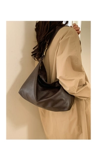 Detailed view of the dark brown leather tote bag with elegant golden strap buckles