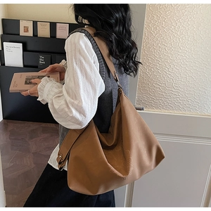 Détail du sac cabas beige avec motif floral en relief et large bandoulière