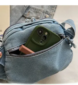 Dettaglio dell'interno della borsa in denim con spazio per smartphone e rossetto