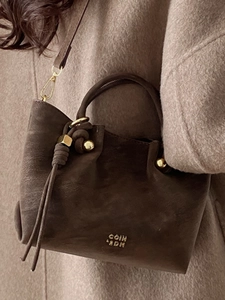 Sac seau vintage en daim marron foncé avec détails dorés et bandoulière élégante