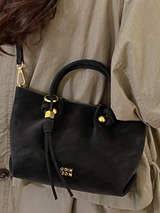 Sac seau vintage noir pour femme avec détails dorés et pompons élégants