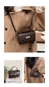 Detail view of retro brown crossbody bag featuring a silver metal twist lock and square shape