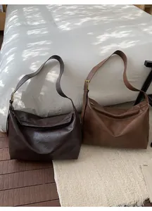 Flat lay of large capacity tote bags in dark coffee and caramel brown matte leather