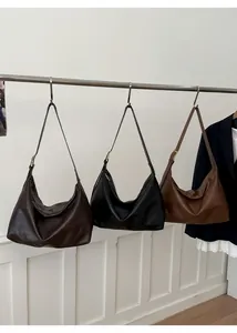 Detailed view of large shoulder bags in chocolate, black and vintage brown leather textures