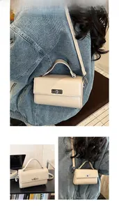 Lifestyle view of the beige crossbody bag showing its compact size and metal lock