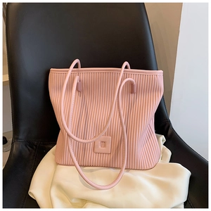 Dettaglio della borsa rosa chiaro con pieghe verticali ed elegante dettaglio quadrato