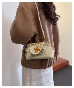 Detailed view of vintage silk shell bag with flower embroidery and double pearl straps