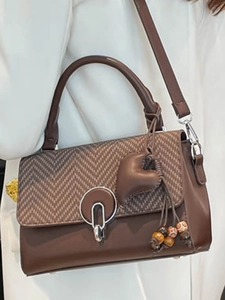 Brown leather crossbody bag with woven flap and decorative bohemian wooden bead charm