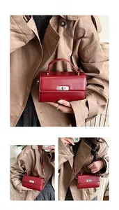 Red leather square bag with silver lock and detachable strap shown on a model