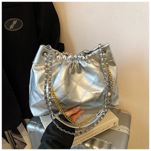 Detail of silver metallic quilted bucket bag with chain strap and pearl accents