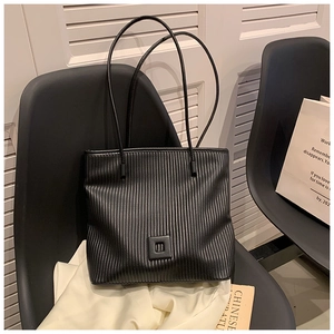 Dettaglio della borsa tote nera a pieghe con decoro quadrato e spalline sottili chic