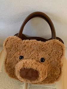 Cute teddy bear head shaped plush handbag with brown faux leather handle and fuzzy texture